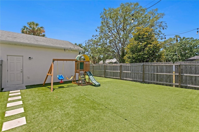 view of yard with a fenced backyard and a playground