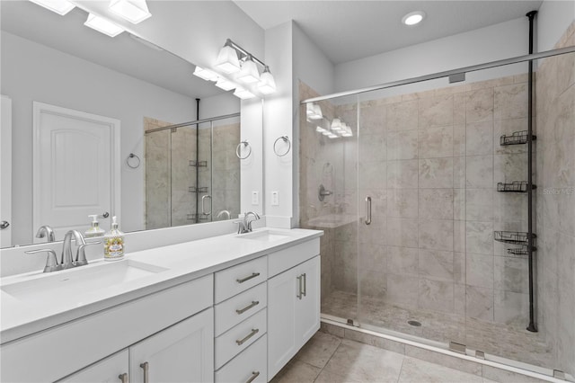 bathroom with double vanity, a shower stall, and a sink