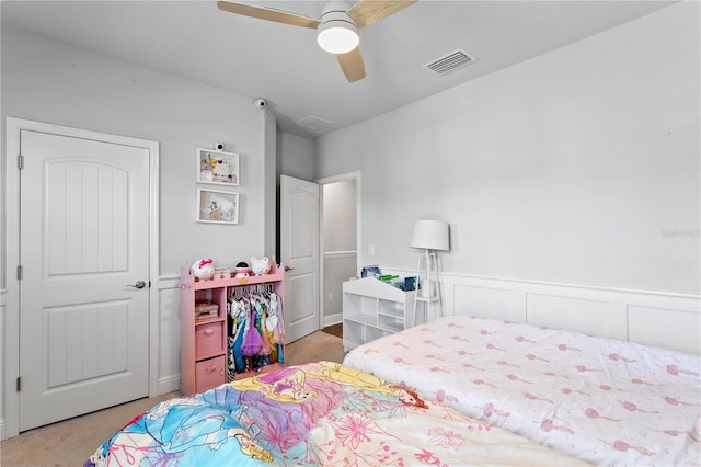 bedroom featuring visible vents, a ceiling fan, wainscoting, and carpet floors