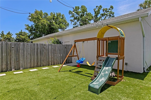 view of playground featuring a fenced backyard and a yard