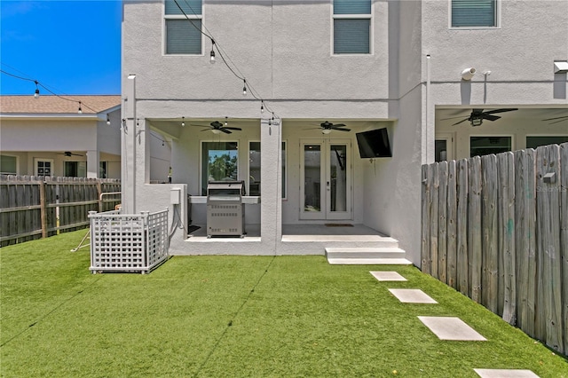 back of house featuring a fenced backyard, ceiling fan, and french doors