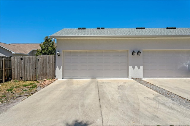 garage with fence and driveway