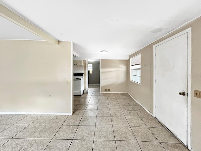 empty room featuring visible vents, baseboards, and light tile patterned floors