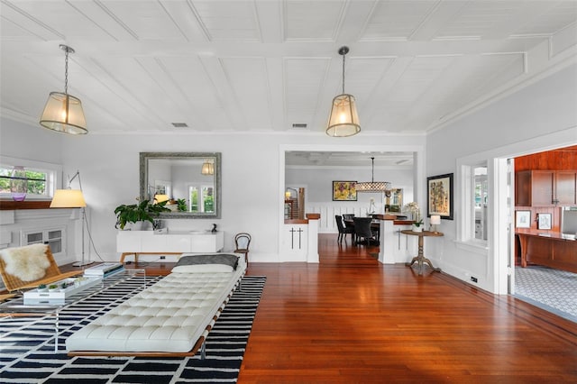 living room featuring visible vents, a decorative wall, wood finished floors, and beam ceiling