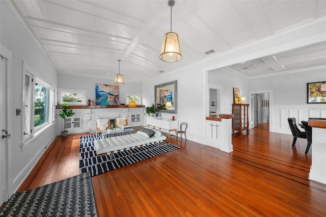interior space with visible vents, crown molding, wood finished floors, beamed ceiling, and coffered ceiling