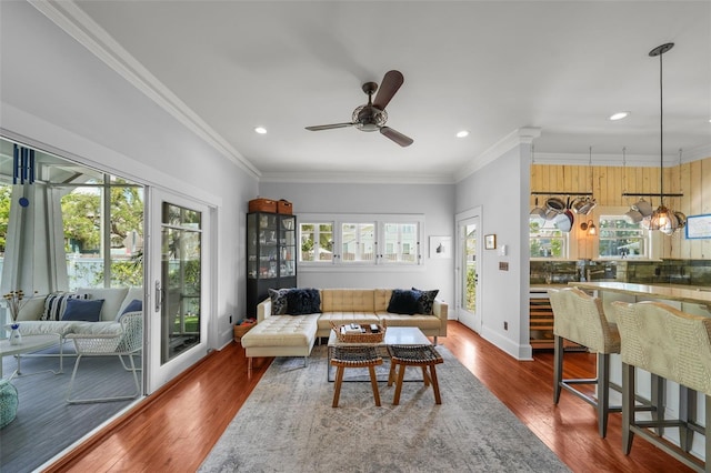 living area featuring recessed lighting, crown molding, ceiling fan, and wood finished floors