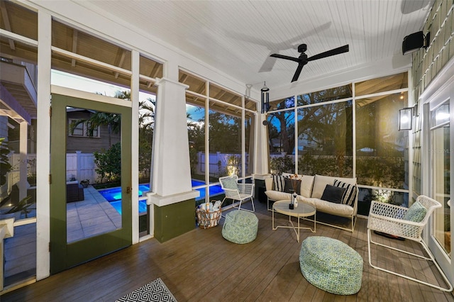 sunroom / solarium with a ceiling fan and an outdoor living space