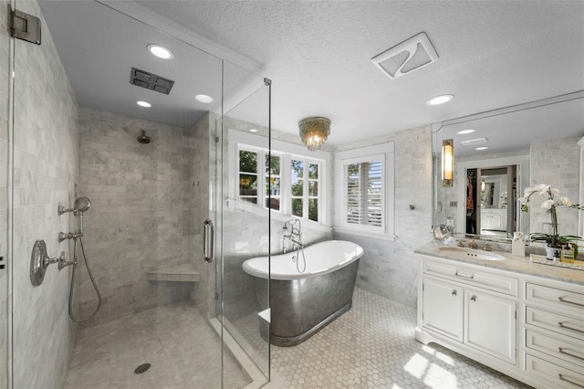 full bath with a freestanding bath, vanity, recessed lighting, a shower stall, and visible vents