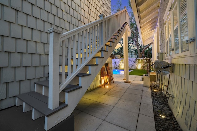 view of patio / terrace with a fenced backyard, a fenced in pool, and stairs