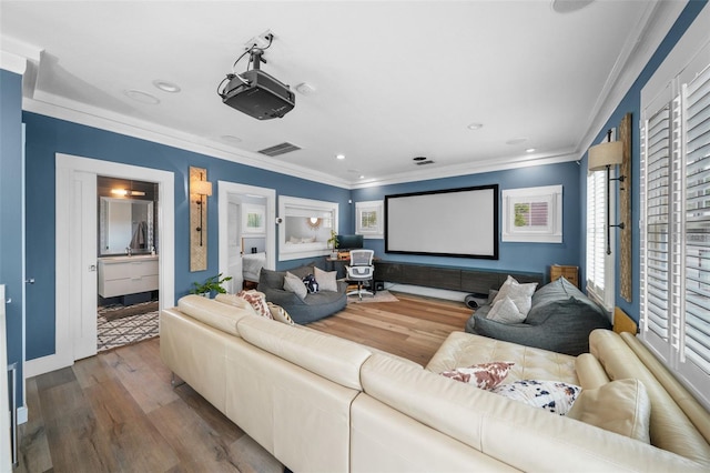 home theater room with baseboards, ornamental molding, recessed lighting, and wood finished floors