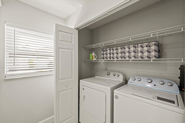 laundry room featuring separate washer and dryer, laundry area, and a textured ceiling