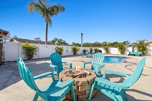 view of patio with a fenced in pool, a fenced backyard, and a fire pit