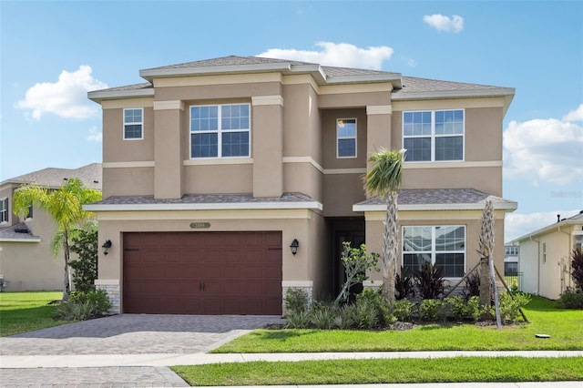 view of front of property featuring a garage, stucco siding, and decorative driveway