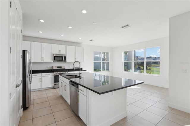 kitchen with stainless steel appliances, dark countertops, light tile patterned flooring, and a sink