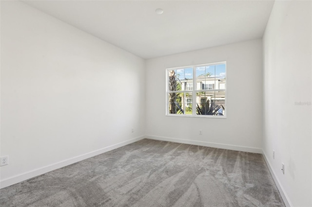 carpeted spare room with baseboards