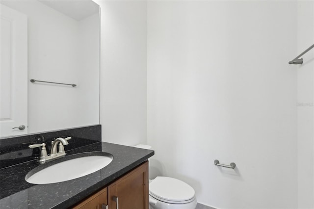 half bath featuring vanity and toilet