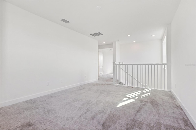 carpeted spare room with visible vents, recessed lighting, and baseboards