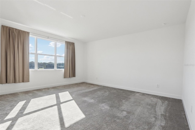 carpeted empty room featuring baseboards