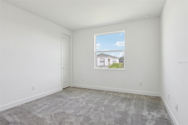 carpeted empty room with baseboards