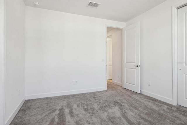 carpeted empty room with baseboards and visible vents