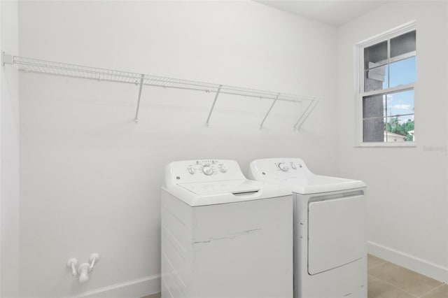 laundry area with separate washer and dryer, baseboards, laundry area, and light tile patterned flooring