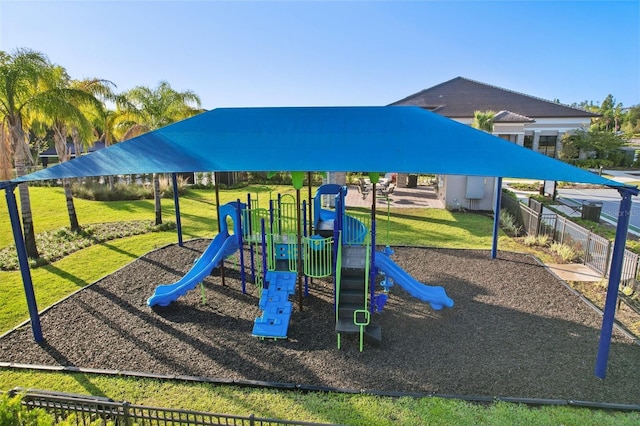 community play area featuring a lawn and fence