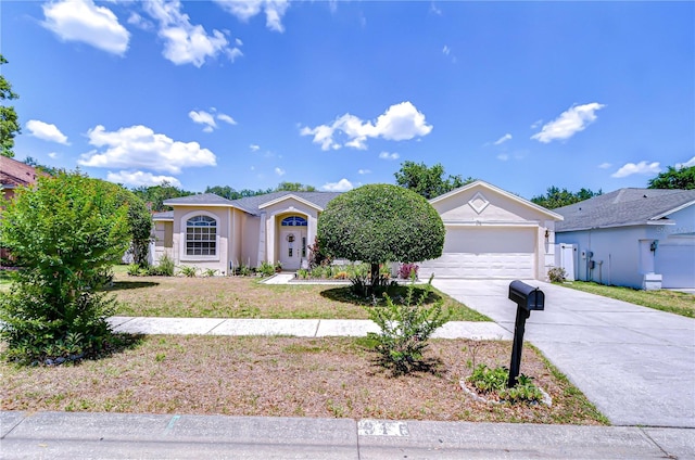 view of front facade with an attached garage, driveway, and stucco siding