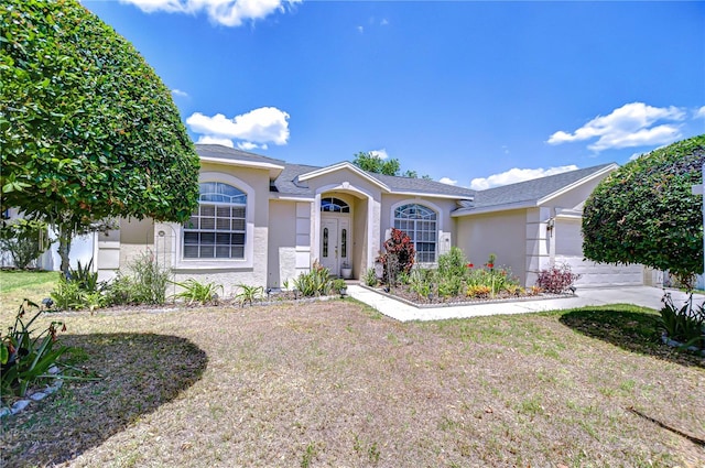 single story home with a garage, stucco siding, and a front yard