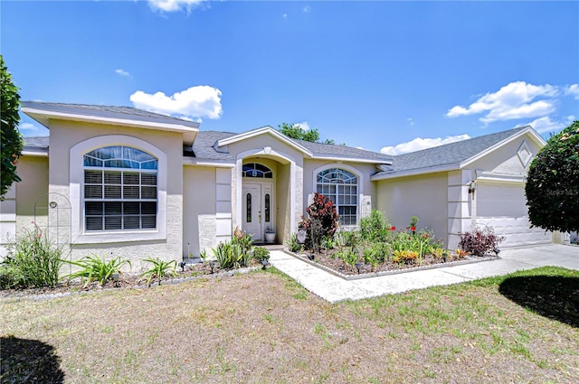 view of front of property with stucco siding and a garage