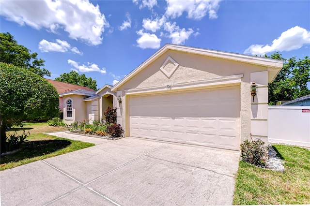 view of front facade with concrete driveway, an attached garage, and stucco siding