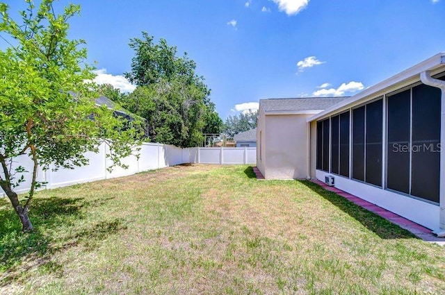 view of yard featuring a fenced backyard and a sunroom