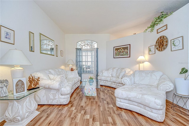 living area with baseboards and light wood finished floors