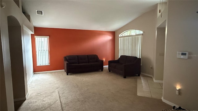 sitting room with tile patterned floors, carpet, baseboards, lofted ceiling, and visible vents