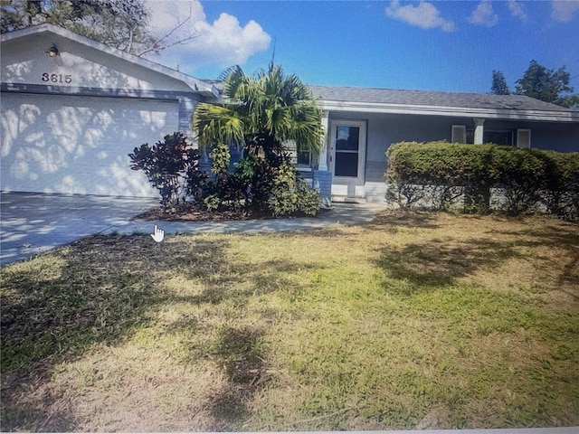 ranch-style home with a garage, stucco siding, concrete driveway, and a front yard