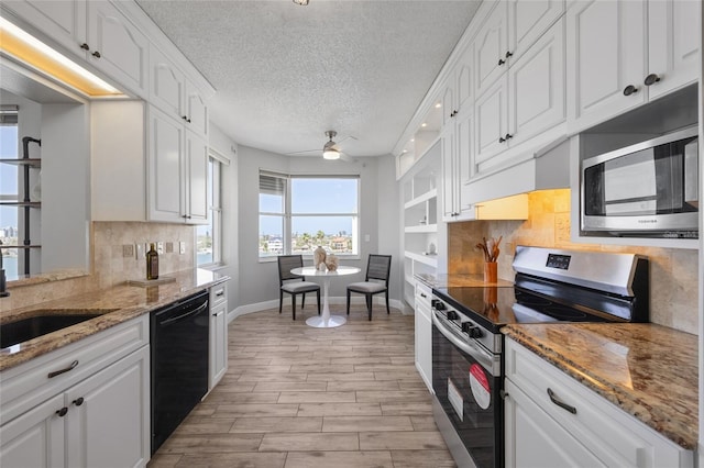 kitchen with baseboards, a textured ceiling, white cabinetry, a ceiling fan, and appliances with stainless steel finishes