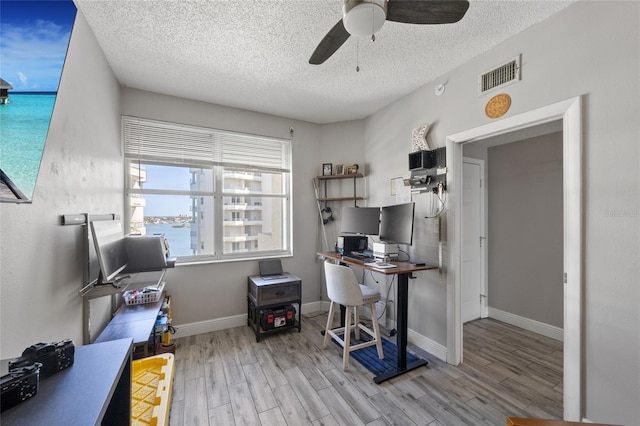 office with visible vents, a textured ceiling, ceiling fan, and wood finished floors