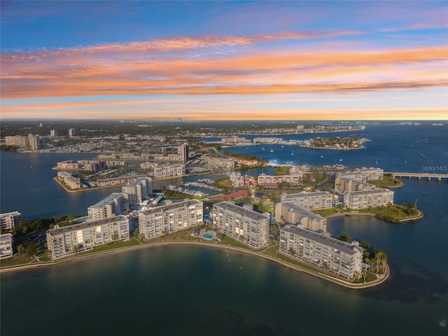 aerial view at dusk featuring a view of city and a water view