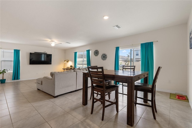 dining space with ceiling fan, baseboards, light tile patterned floors, and visible vents