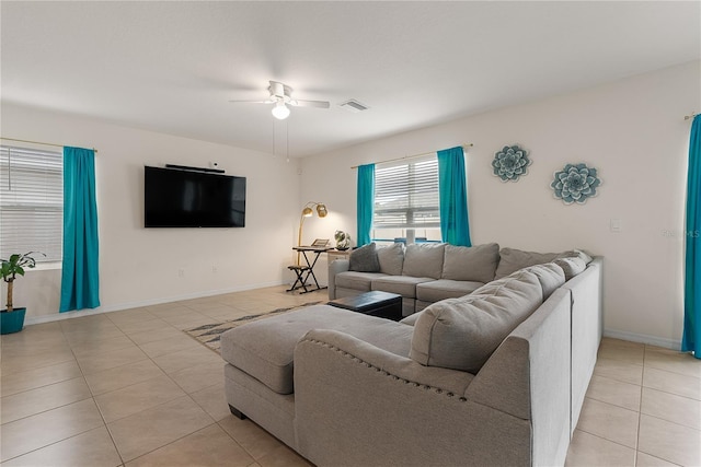 living room with a ceiling fan, visible vents, baseboards, and light tile patterned flooring