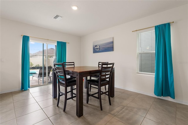 dining area featuring baseboards, visible vents, and light tile patterned flooring