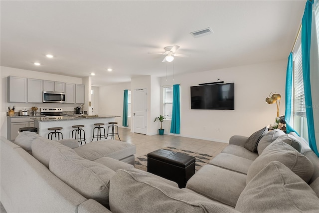 living area with visible vents, recessed lighting, a ceiling fan, light tile patterned floors, and baseboards