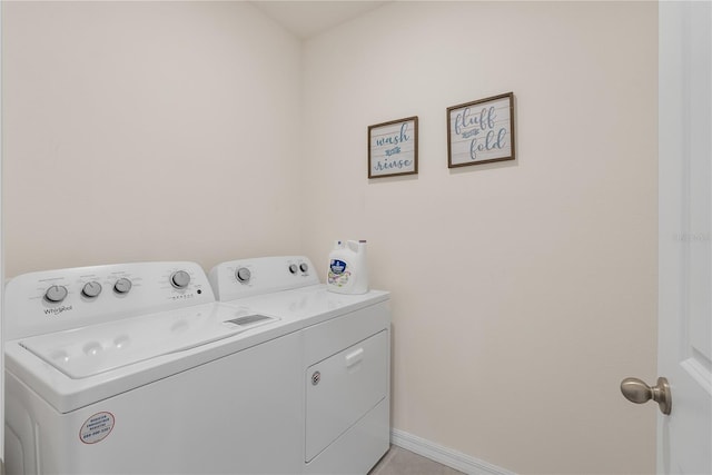 washroom featuring washer and dryer, laundry area, and baseboards