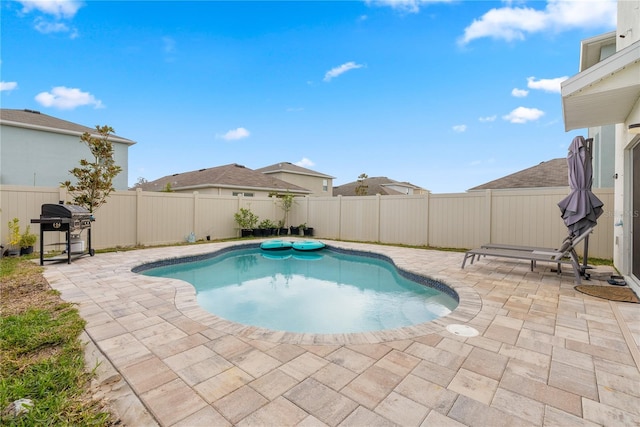 view of pool with a fenced backyard, a patio area, a fenced in pool, and a grill