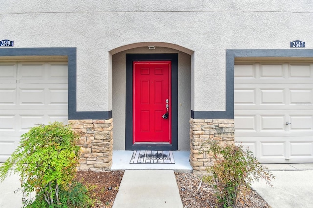2547 Lexington Oak Dr, Brandon, FL 33511 - view of exterior entry with stone siding, stucco siding, and a garage
