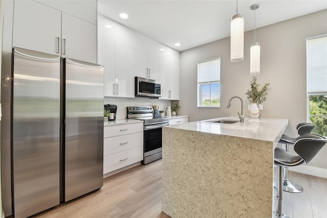 2547 Lexington Oak Dr, Brandon, FL 33511 - kitchen featuring appliances with stainless steel finishes, a sink, light wood-style floors, white cabinets, and tasteful backsplash