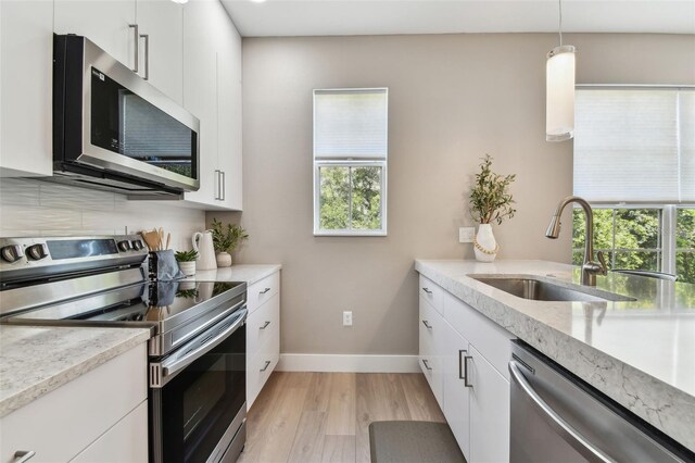 2547 Lexington Oak Dr, Brandon, FL 33511 - kitchen featuring appliances with stainless steel finishes, a sink, light wood-style floors, baseboards, and white cabinets