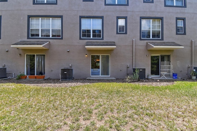 2547 Lexington Oak Dr, Brandon, FL 33511 - rear view of property featuring central AC unit, stucco siding, and a lawn