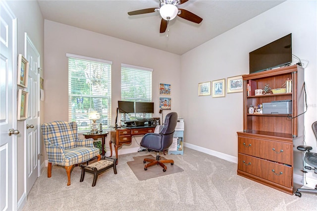 carpeted office space with ceiling fan and baseboards