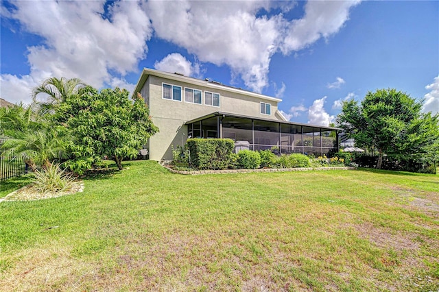 exterior space featuring a lawn, fence, stucco siding, and a sunroom