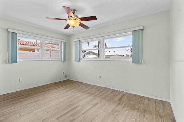 unfurnished room featuring light wood-type flooring, a ceiling fan, and baseboards